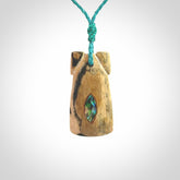A stunning hand carved Woolly Mammoth Tusk Toki pendant. The toki has a small oval shaped piece of Pāua shell inset into the front face. This piece is bound with an adjustable cord. This is a little piece of Art to wear.
